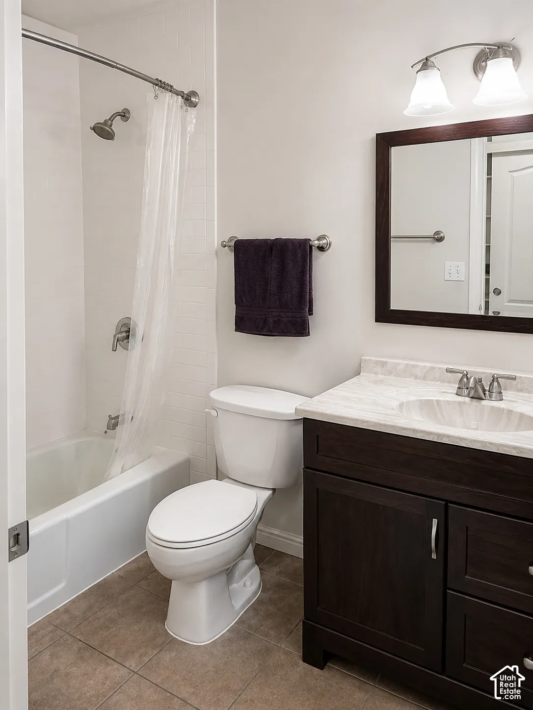 Dark wood-finish vanity with a light-toned countertop, integrated sink, and brushed nickel hardware