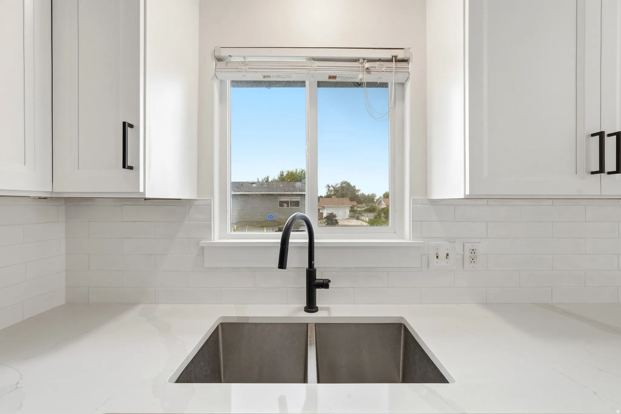 Stainless steel double basin sink with a matte black faucet