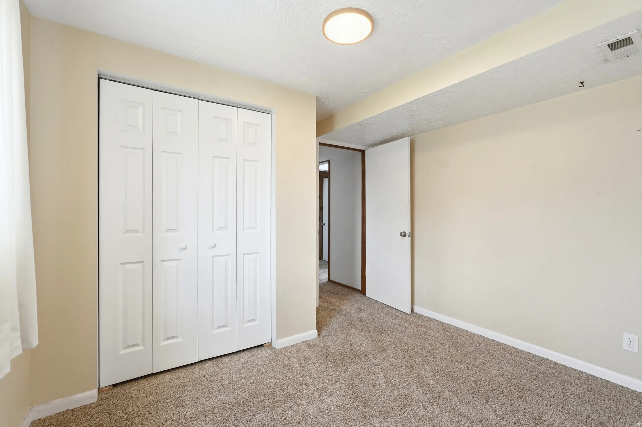 Bedroom featuring neutral carpeting and light-toned wall paint