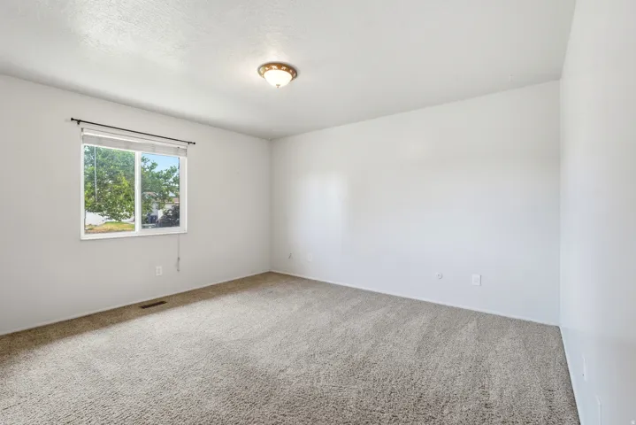 Spacious room featuring neutral carpeting and white painted walls