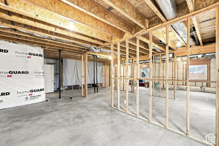 Unfinished basement with concrete flooring and exposed ceiling joists