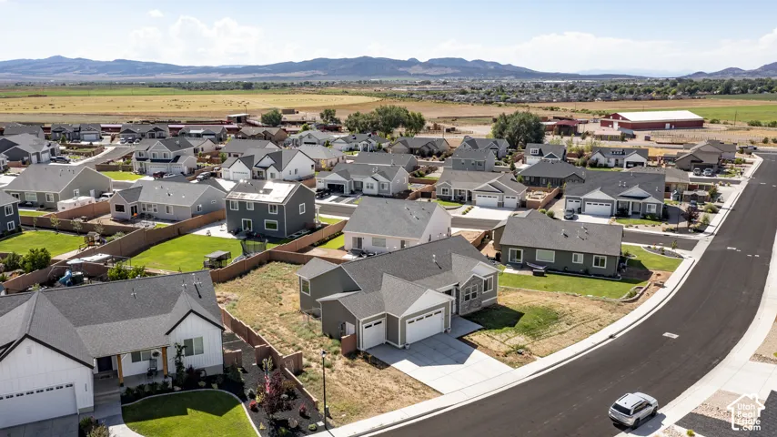 Aerial perspective showcasing a residential neighborhood with varied single-family homes, paved roads, and sidewalks