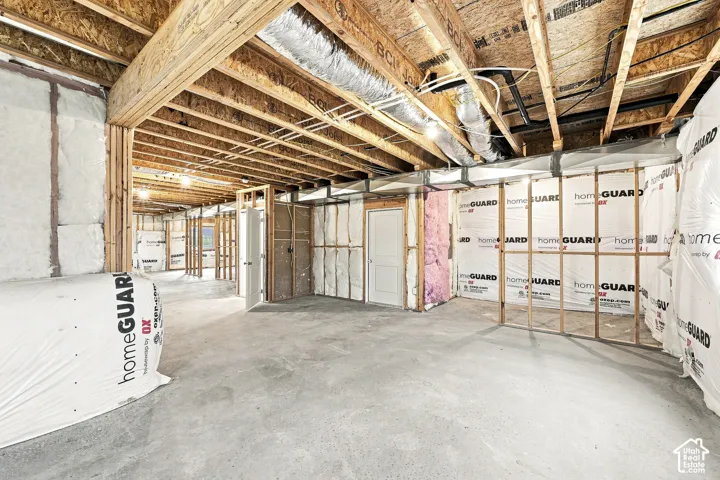 Unfinished basement featuring exposed wood joists and concrete flooring