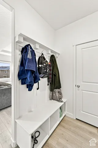 Built-in white storage bench featuring cubbies and upper hanging hooks