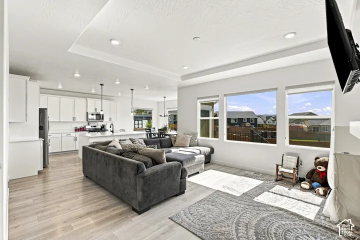 Open-concept living space featuring wood-finish flooring, recessed lighting, and large windows