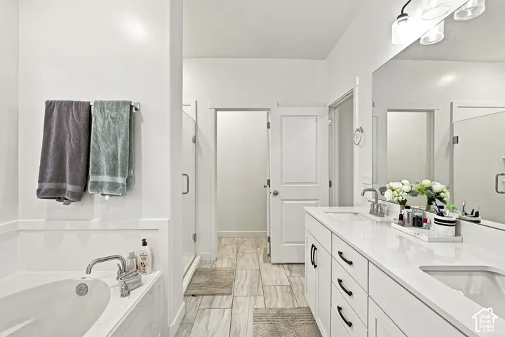 Contemporary bathroom featuring a double vanity with white cabinetry and quartz countertops
