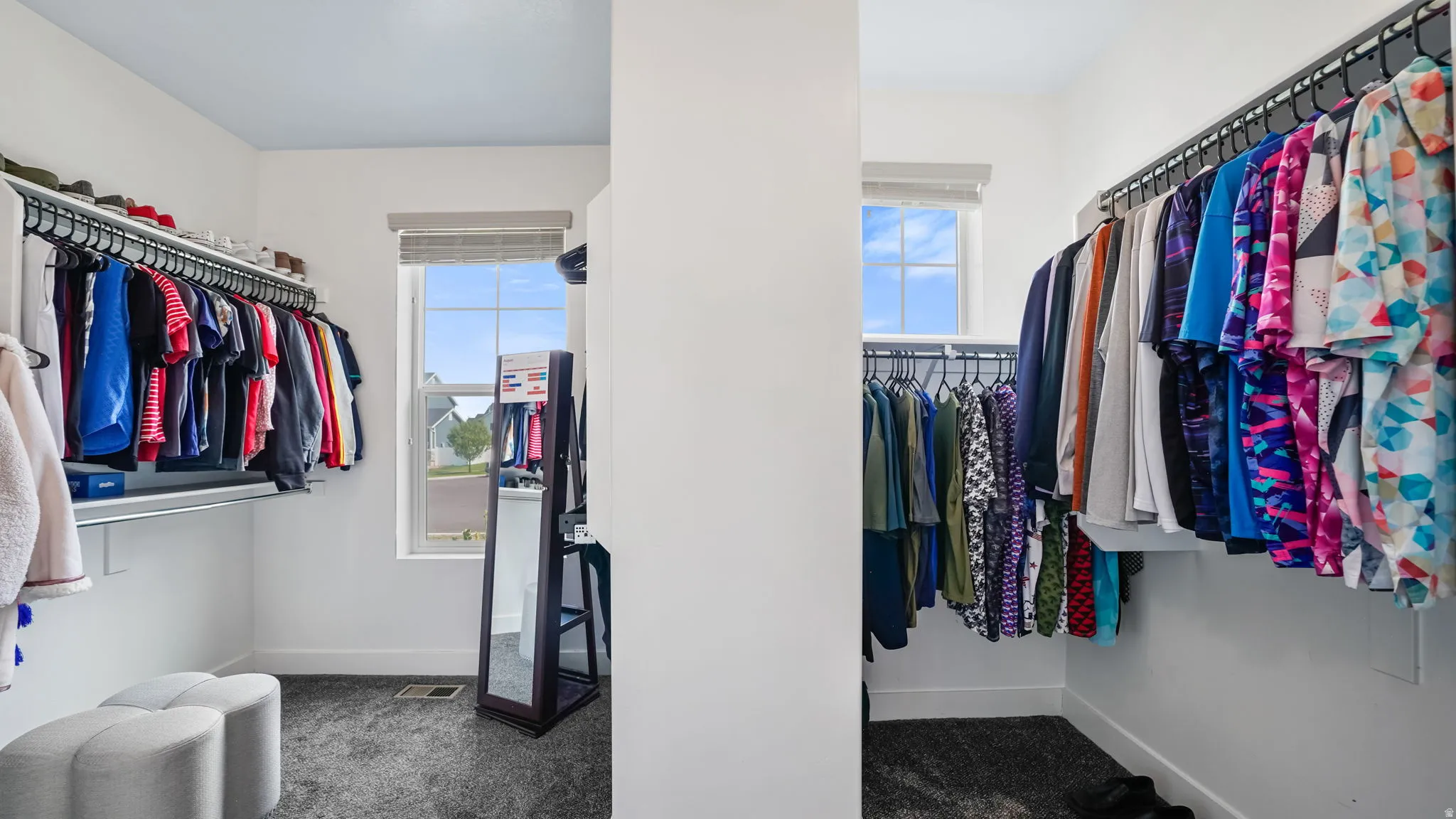 Walk-in closet featuring built-in shelving, hanging rods, and a window with blinds