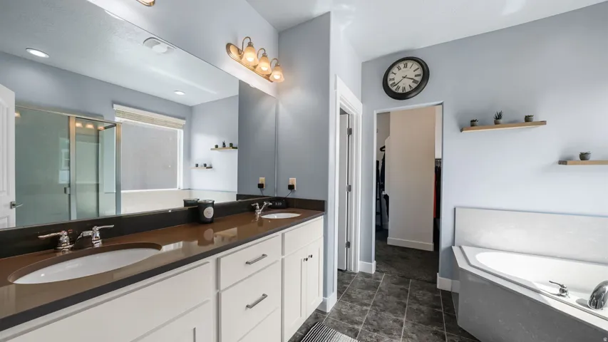 Primary bathroom> Dual vanity with undermount sinks, bronze-toned countertop, and chrome fixtures