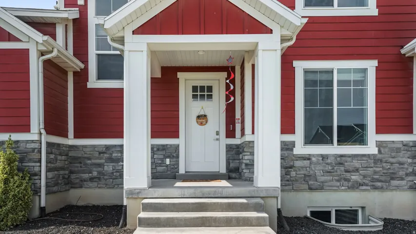 Covered front entry with white columns and red siding