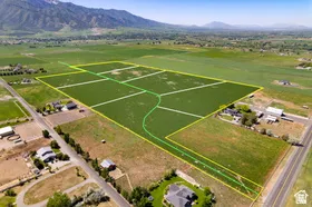 Expansive agricultural land featuring delineated parcels and mountain scenery