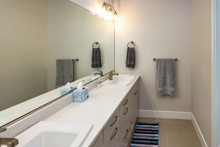 Dual undermount sinks set into a light-toned countertop with integrated backsplash