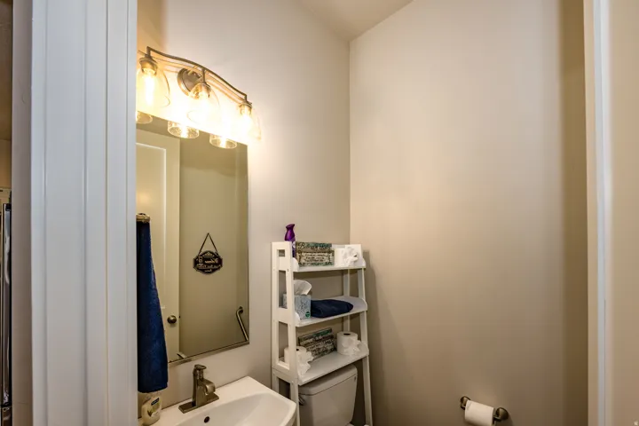 Bathroom vanity featuring a rectangular sink, wall-mounted mirror, and brushed metal faucet