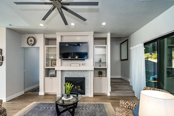 Built-in entertainment center featuring a fireplace with stone surround, integrated shelving, and closed cabinetry