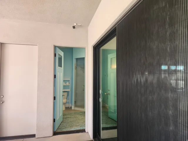 Bathroom featuring light blue walls, a walk-in shower with a glass enclosure, and a white toilet