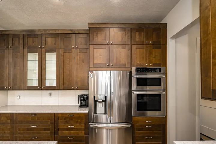 Modern kitchen featuring full-height wood cabinetry with glass-front accents