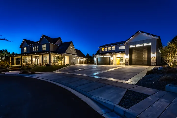 Craftsman-style residence featuring a covered front porch, multiple dormer windows, and a combination of horizontal siding and stone accents