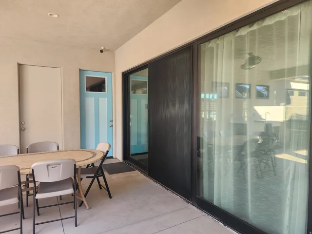 Covered outdoor patio featuring a concrete surface, recessed ceiling lighting, and a unique light blue entry door