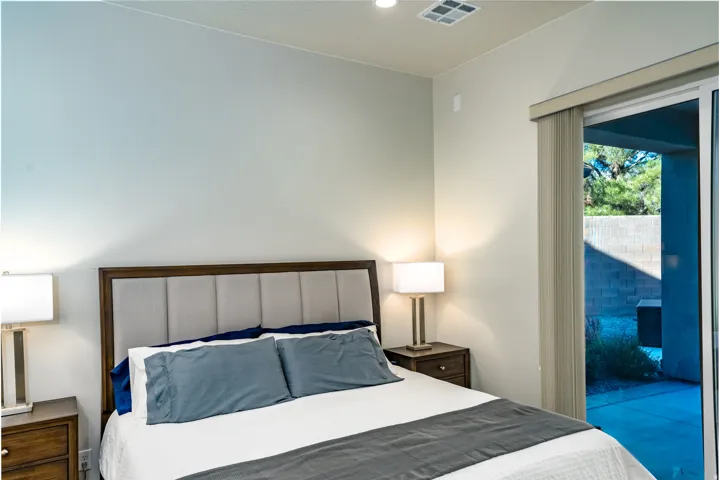 Bedroom featuring a contemporary upholstered headboard and direct access to an outdoor patio through a sliding glass door
