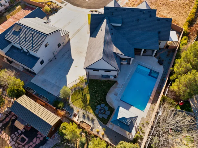 Modern main residence with a detached guesthouse, a large swimming pool with an integrated spa, a dedicated gazebo, and a hardscaped fire pit area