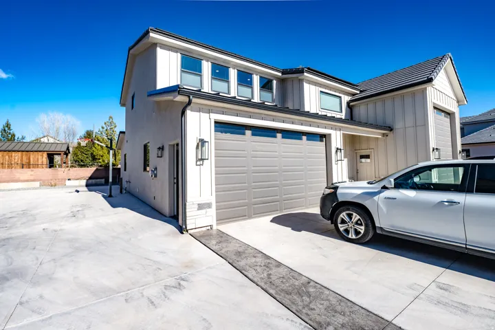 Modern exterior featuring vertical board and batten siding, stucco, and a dark tile roof