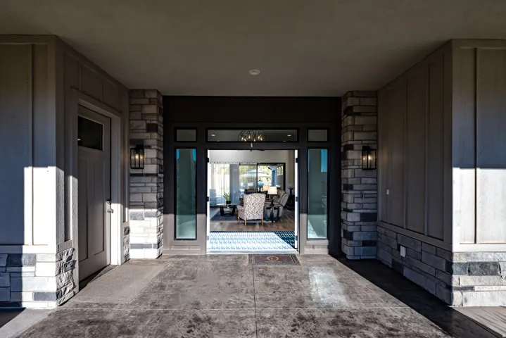 Covered entry with stone veneer accents and vertical siding