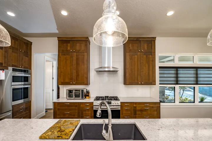 Modern kitchen island with an undermount sink, a gooseneck faucet, and light-toned countertops