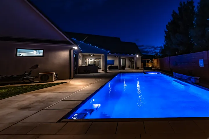 Rectangular swimming pool with integrated spa and blue underwater lighting