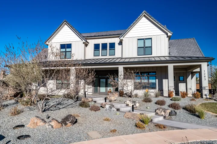 Modern farmhouse exterior with board and batten siding, stone accents, and a covered porch