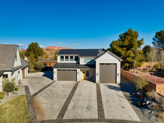 Contemporary exterior with white siding and dark trim, featuring a dual two-car garage
