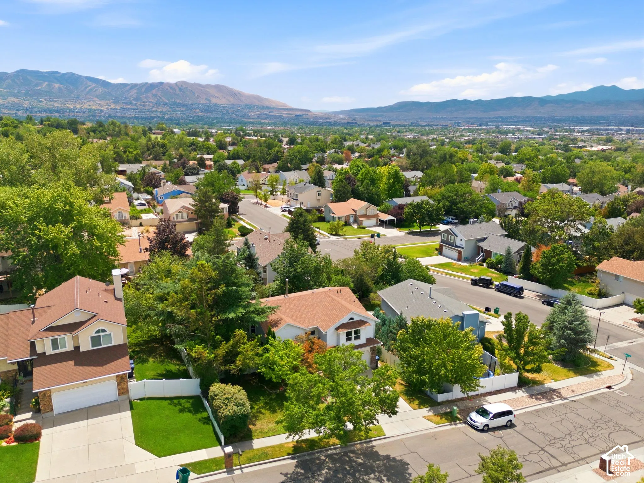 Residential neighborhood featuring mature trees and mountain scenery