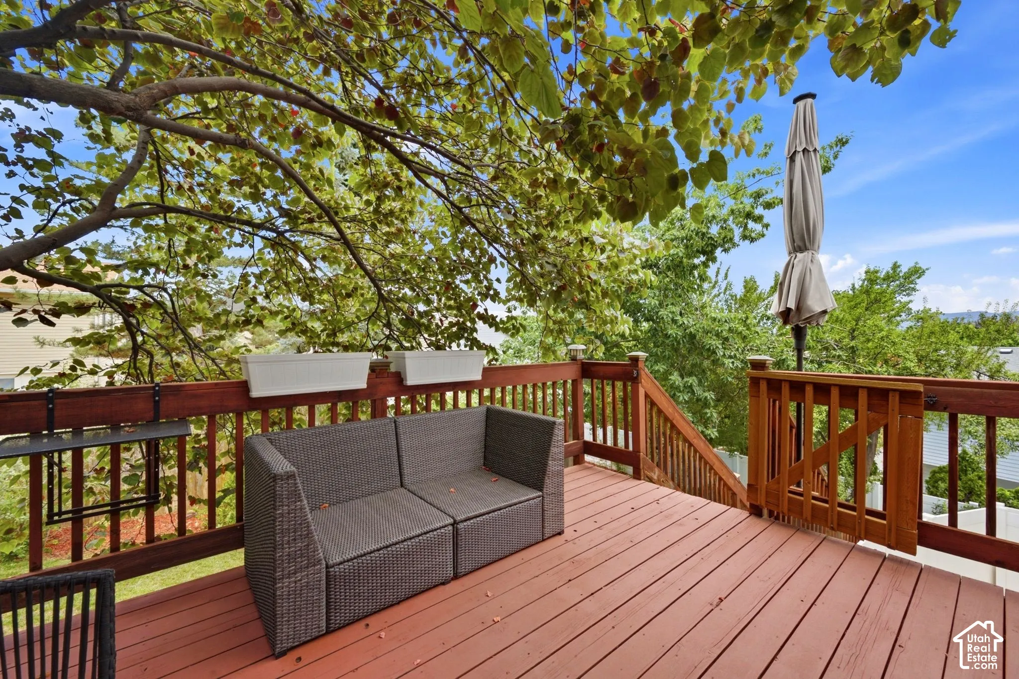 Expansive wood deck with rich red-brown stain, featuring a full wood railing system and a gate