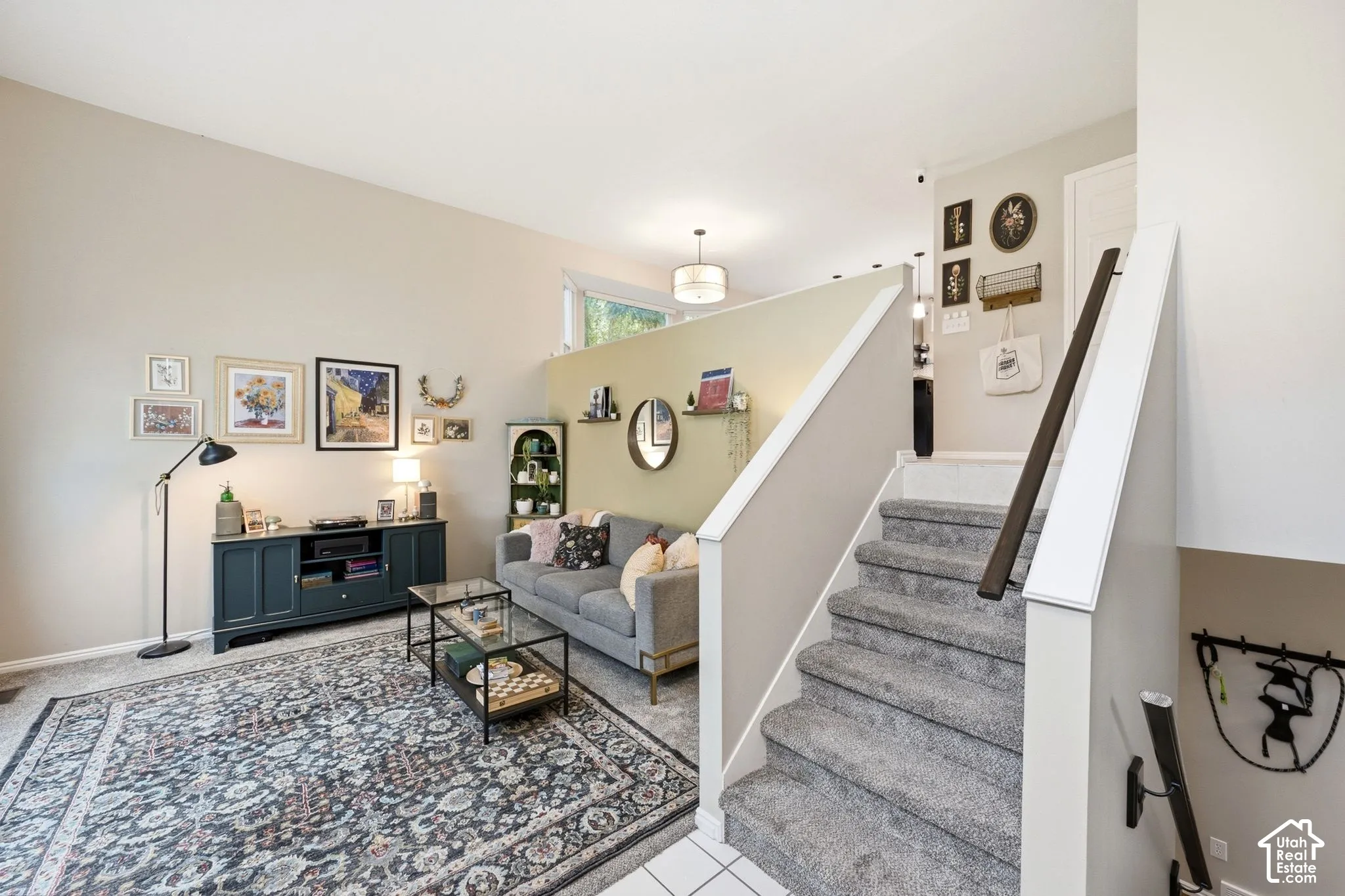 Living area featuring neutral wall tones, a high ceiling, and a partial wall dividing the space