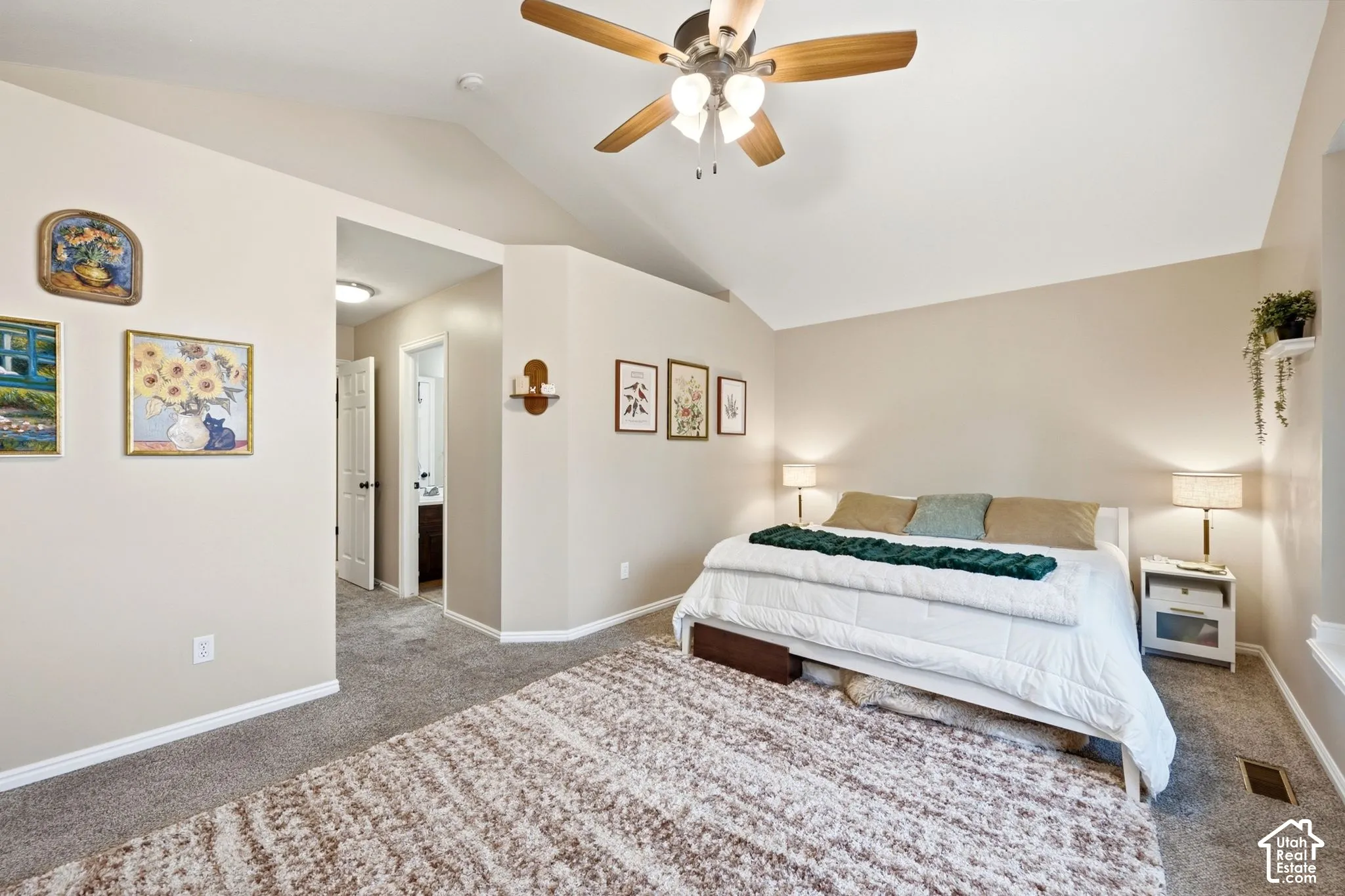 Carpeted sleeping area featuring a vaulted ceiling and a ceiling fan with integrated lighting
