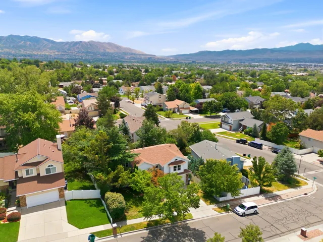 Residential neighborhood featuring mature trees and mountain scenery