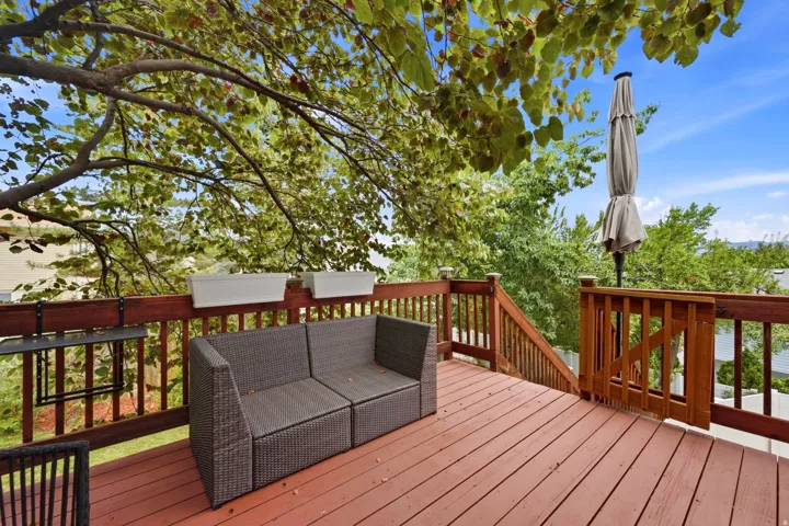 Expansive wood deck with rich red-brown stain, featuring a full wood railing system and a gate
