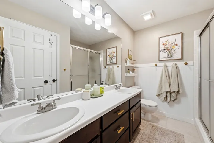 Bathroom featuring a dual sink vanity with dark wood-finish cabinetry, white countertops, and brushed nickel faucets