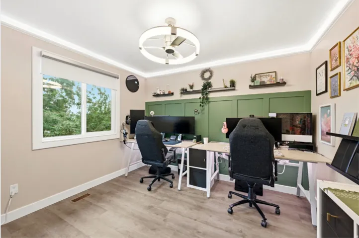 Spacious room featuring wood-finish flooring, a large window, crown molding, and a modern ceiling fan with integrated lighting