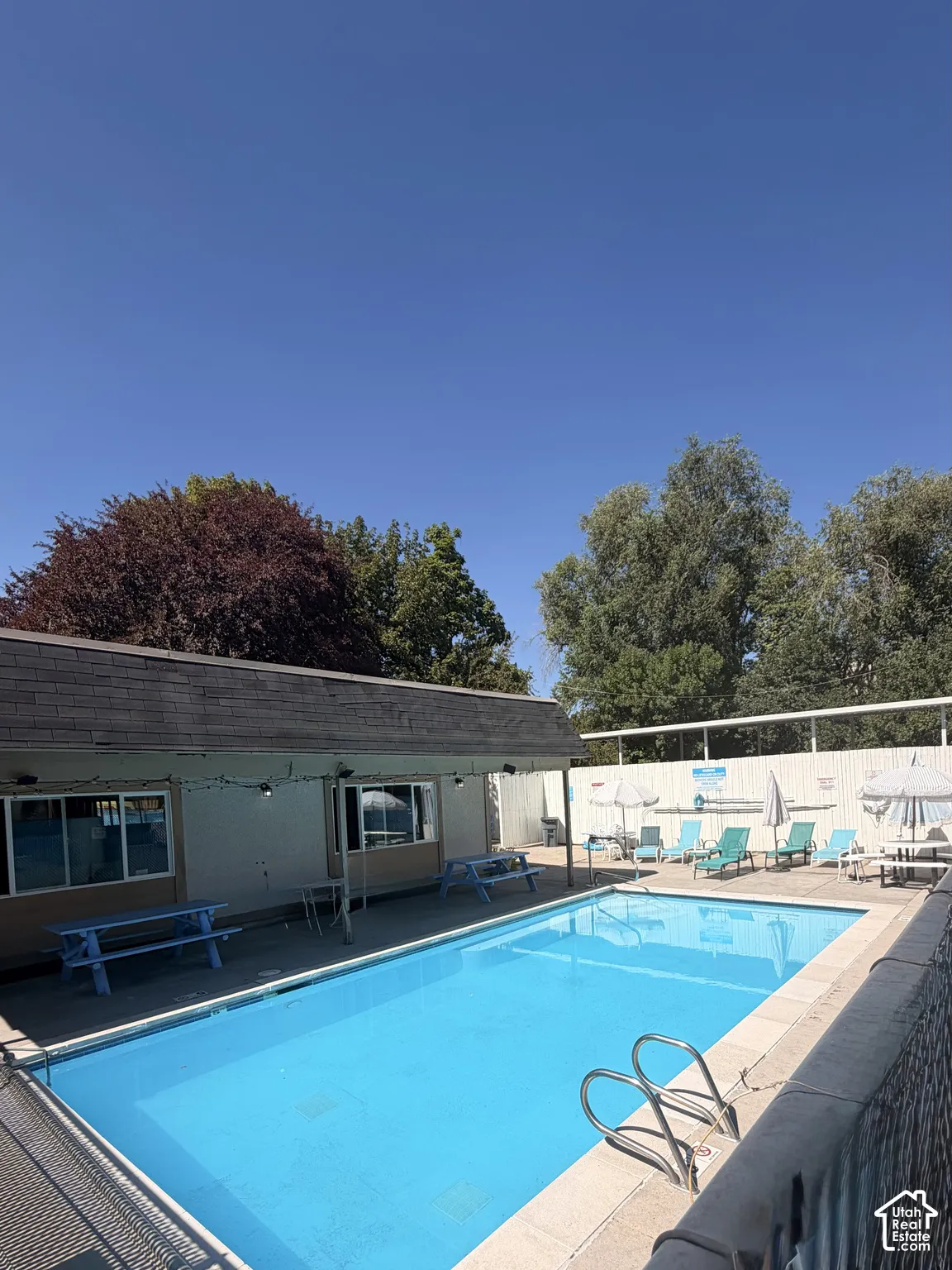 Refreshing swimming pool with lounge area and gym facility indoors.