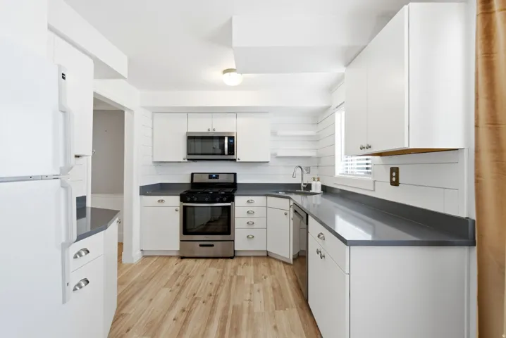 Bright and updated kitchen with quartz countertops and shiplap wall detail.