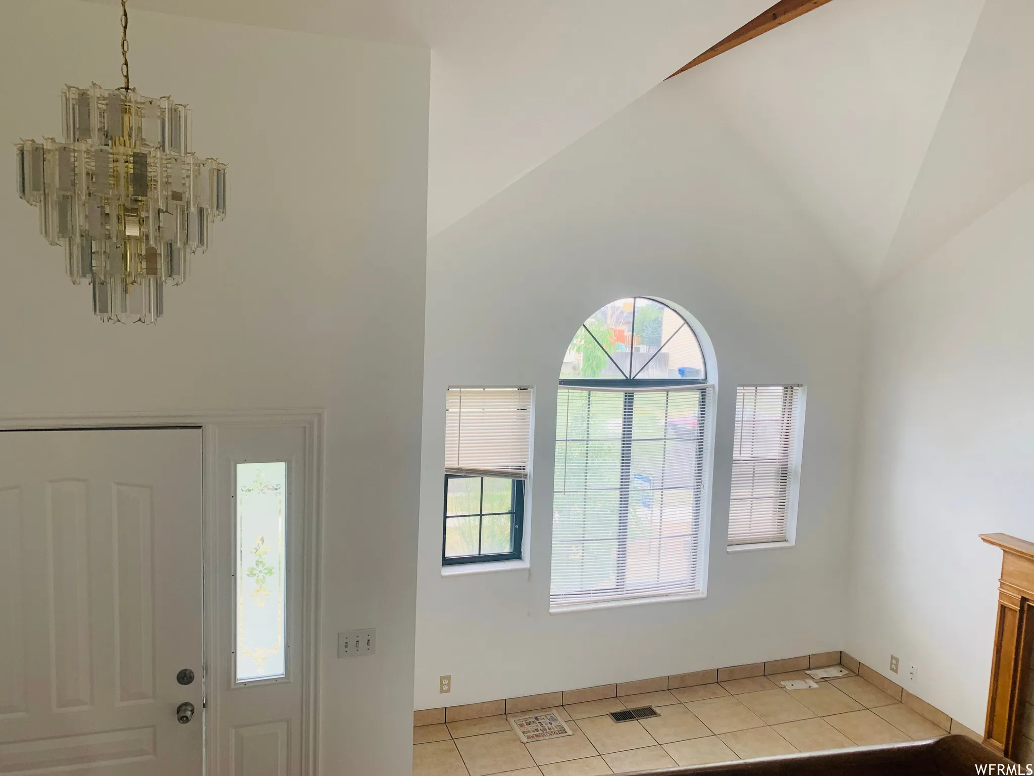 Vaulted ceilings featuring a prominent crystal chandelier