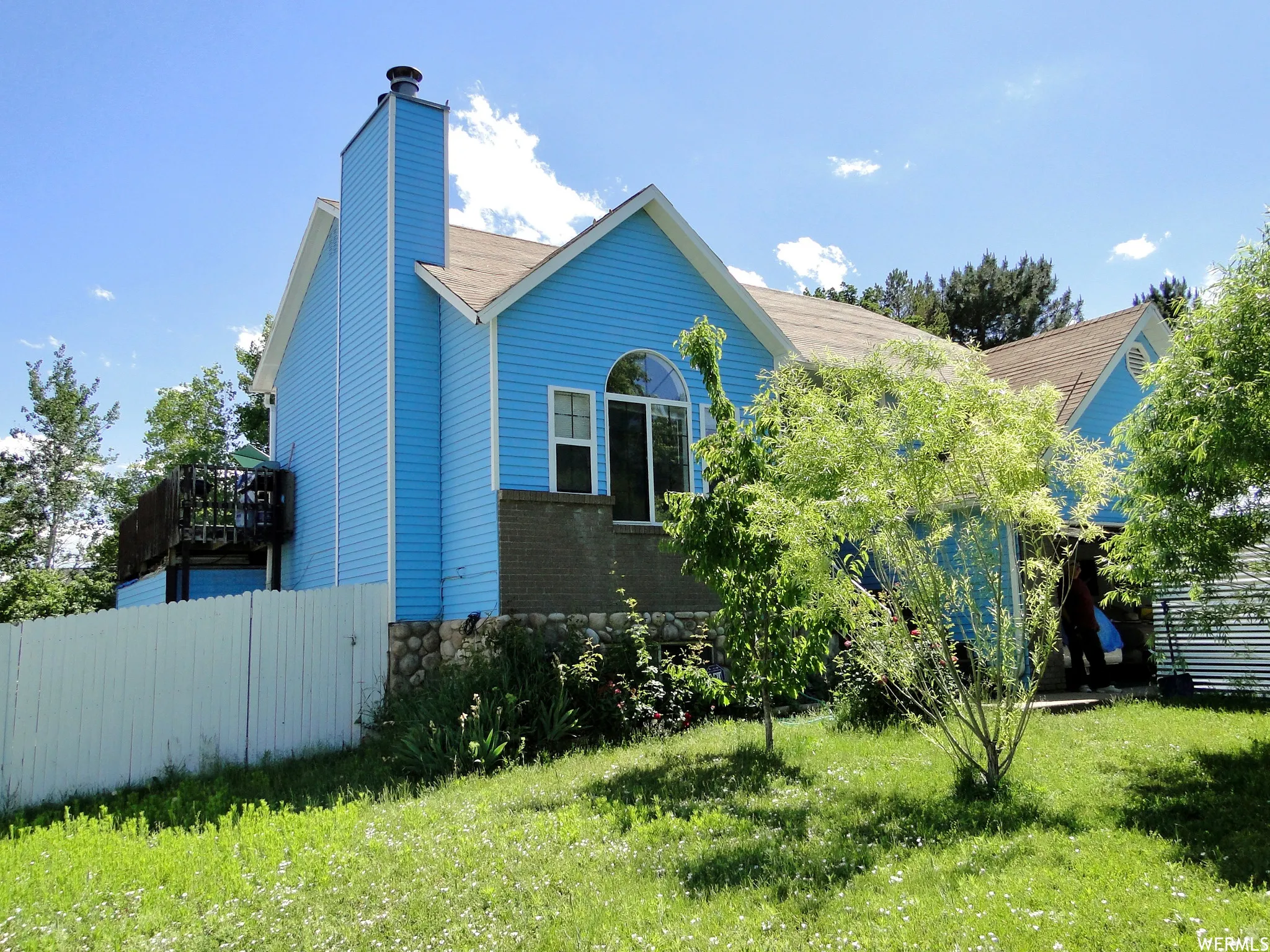 Two-story residence featuring blue siding and a light-colored roof