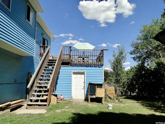 Upper-level deck with wood railing, accessed by exterior wood stairs