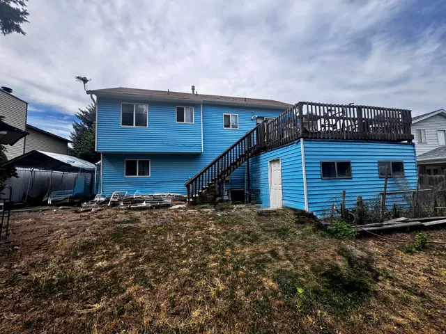 Two-story residence featuring blue horizontal siding and multiple windows