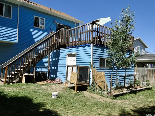 Upper-level deck with wood railing, accessed by an exterior wood staircase