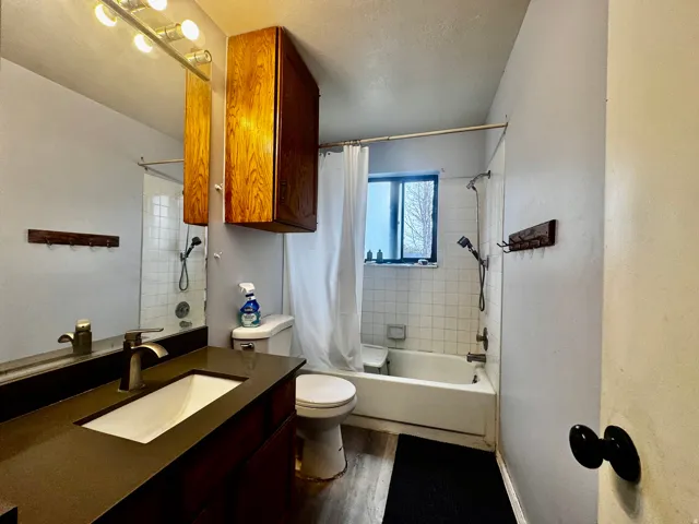Bathroom featuring a vanity with an integrated rectangular sink, a dark countertop, and a brushed nickel faucet