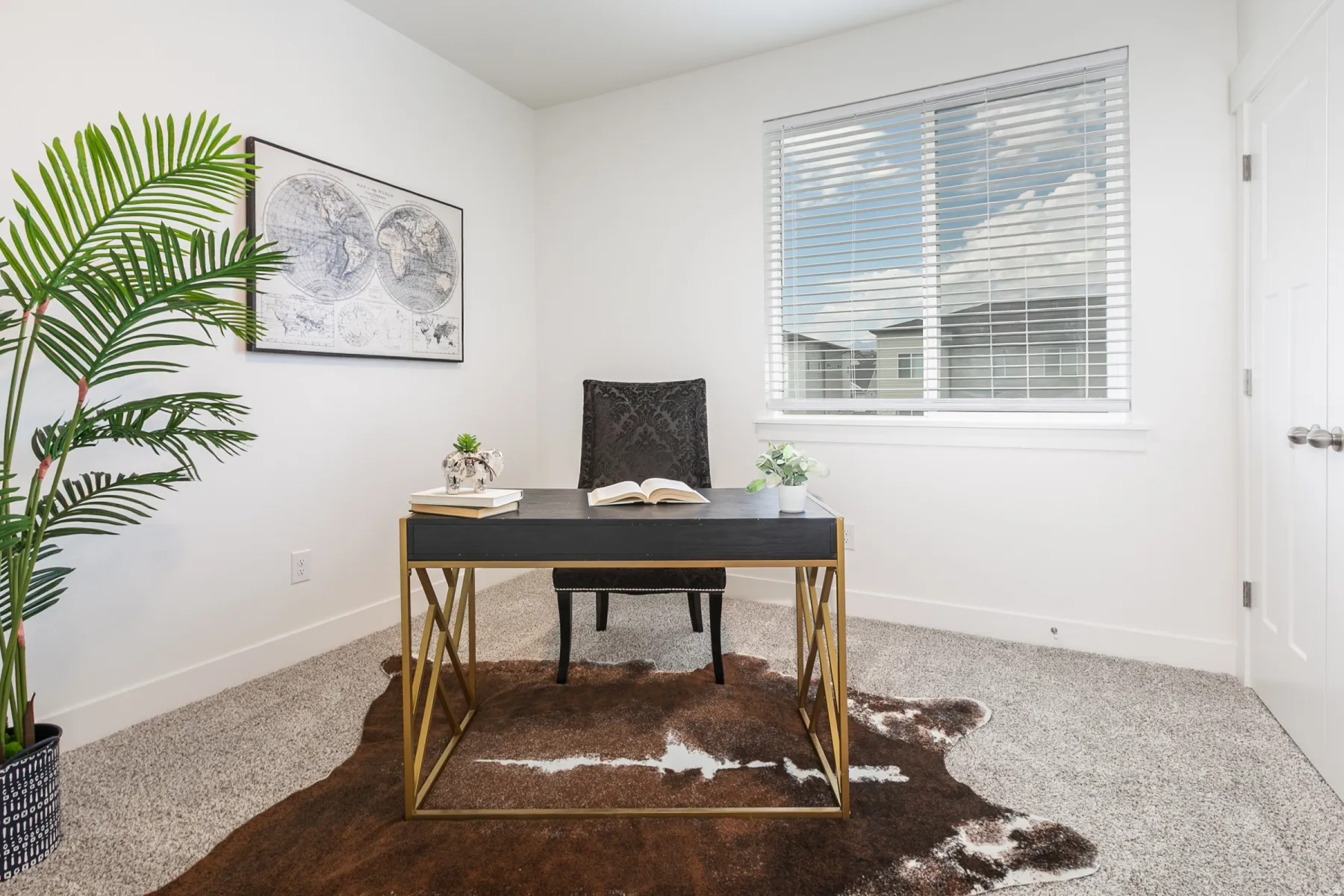 Bright interior space featuring a window with horizontal blinds, neutral wall paint, and gray carpet