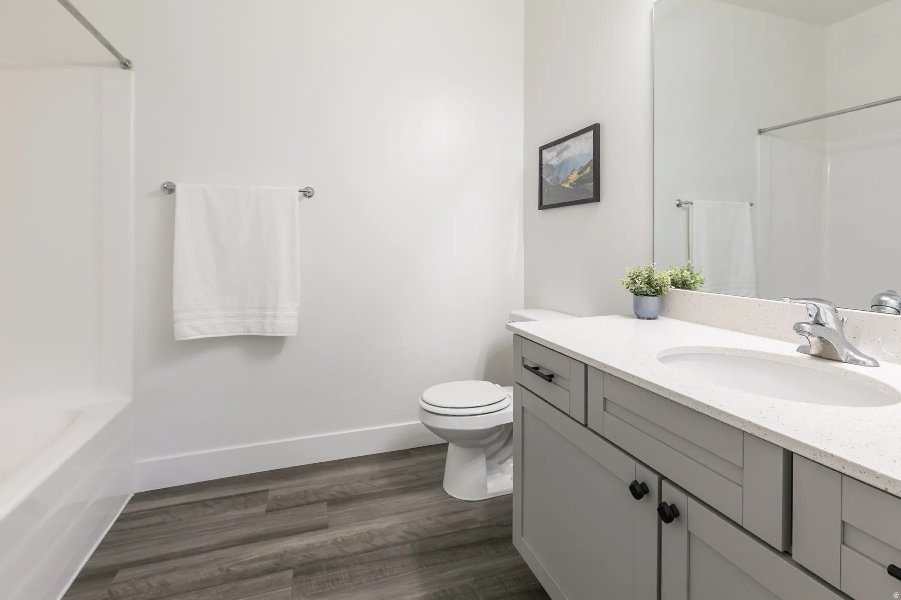 Bathroom featuring a light gray vanity with black hardware, white countertop, and integrated sink
