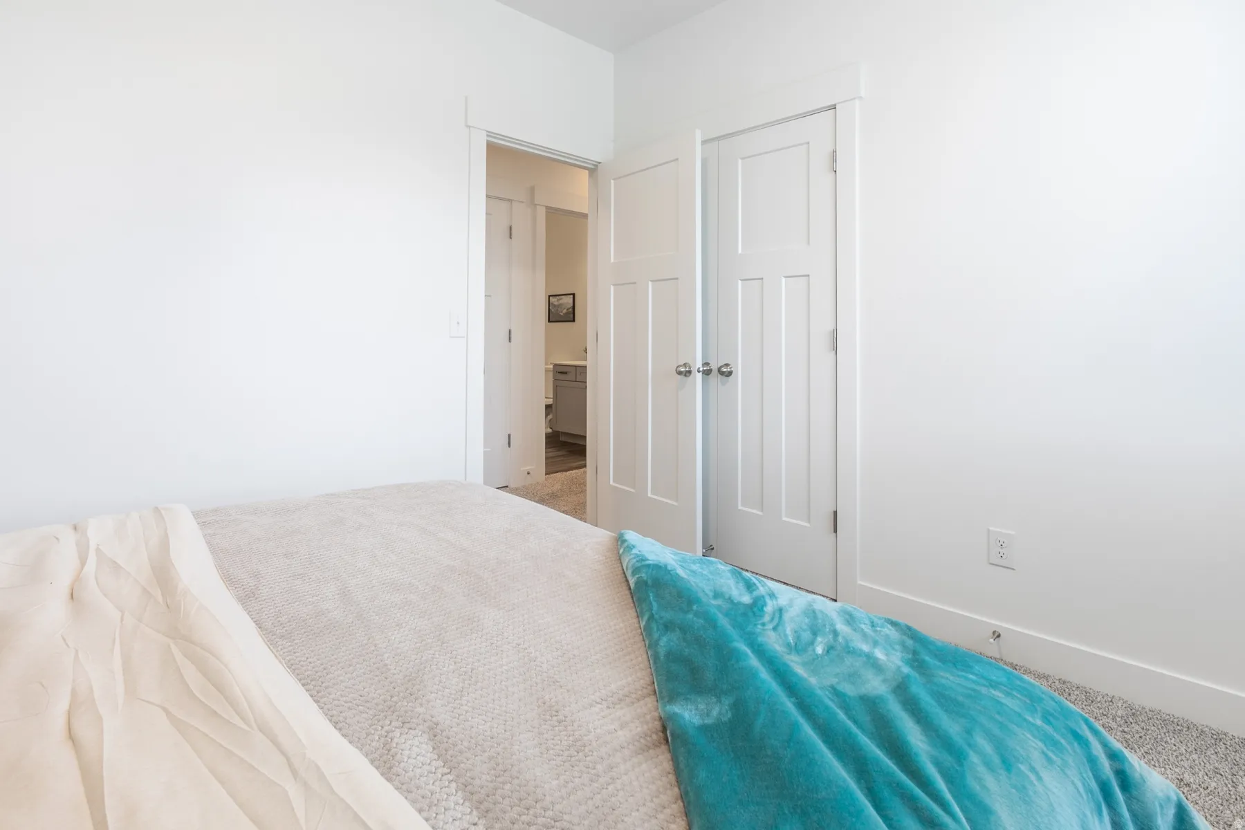 Neutral bedroom featuring white walls, white trim, and light grey carpet