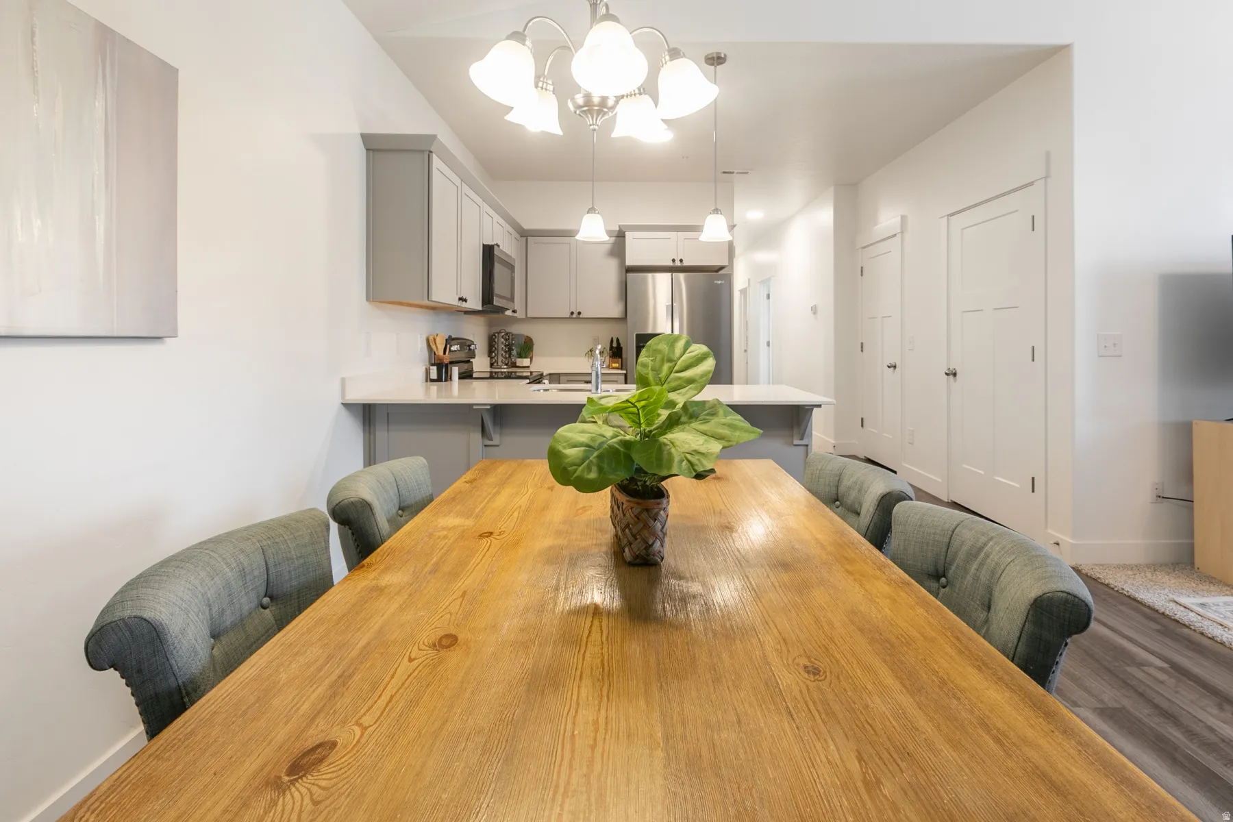 Open-concept dining and kitchen area with light wood-finish flooring