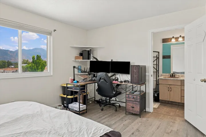 Bedroom featuring wood-finish flooring and a white window frame